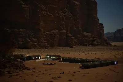 a group of buildings in the desert at night at Salman Zwaidh Camp in Wadi Rum