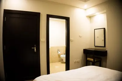 a bedroom with a bed and a bathroom with a toilet at Madaba Hotel in Madaba