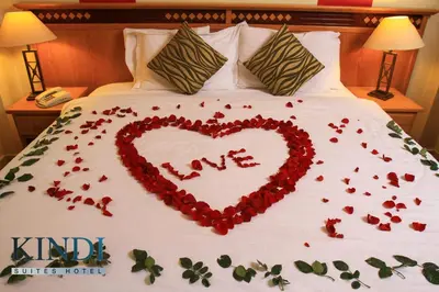 a heart made out of flowers on a bed at Kindi Suite Hotel in Amman