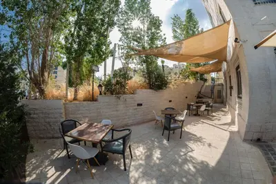 a patio with tables and chairs and a brick wall at Kindi Suite Hotel in Amman