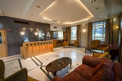 a lobby with couches and a table and a bar at Kindi Suite Hotel in Amman
