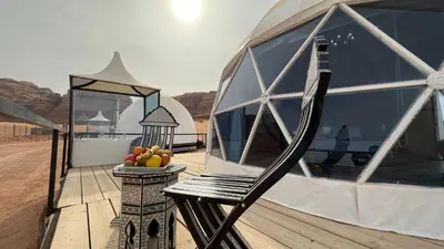 a chair sitting on a deck with a bowl of fruit at Mazayen Rum Camp in Wadi Rum