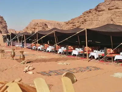 a restaurant with tables and chairs in the desert at Mazayen Rum Camp in Wadi Rum