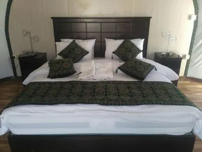 a large bed with white sheets and pillows at Mazayen Rum Camp in Wadi Rum