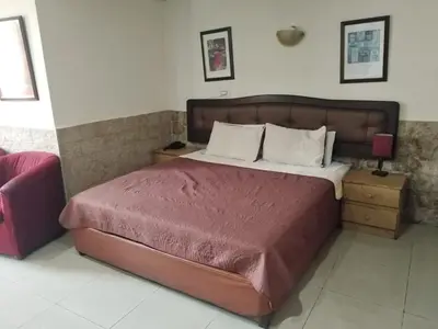 a bedroom with a large bed with a wooden headboard at Amman Palace Hotel in Amman
