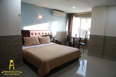a bedroom with a large bed and a dining room at Amman Palace Hotel in Amman