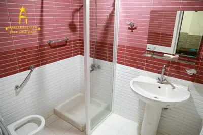 a red and white bathroom with a sink and a shower at Amman Palace Hotel in Amman