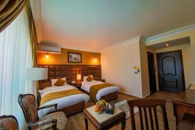 a hotel room with two beds and a table at Town Season Hotel in Wadi Musa