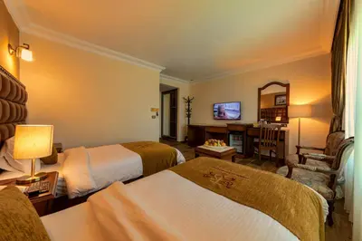 a hotel room with two beds and a television at Town Season Hotel in Wadi Musa