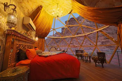a bedroom with a bed in a pyramid shaped room at Memories Aicha Luxury Camp in Wadi Rum
