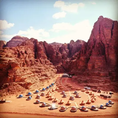 a group of umbrellas on a beach in a canyon at Memories Aicha Luxury Camp in Wadi Rum