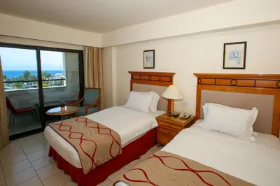 a hotel room with two beds and a balcony at Mina Hotel in Aqaba