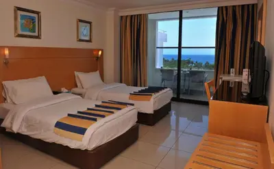 a hotel room with two beds and a balcony at Mina Hotel in Aqaba