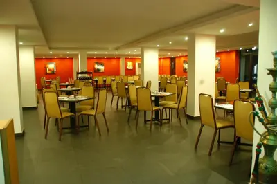 a restaurant with tables and chairs and red walls at Mina Hotel in Aqaba