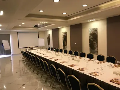 a large meeting room with a long table and chairs at Capri Hotel Suites in Amman