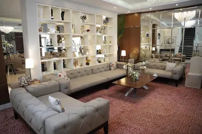 a living room with couches and shelves of vases at Lijam Hotel in Amman