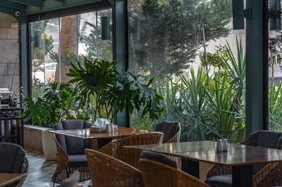 a restaurant with tables and chairs and plants at Guest House Hotel Amman by FHM in Amman