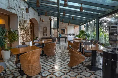 a restaurant with tables and chairs in a room at Guest House Hotel Amman by FHM in Amman