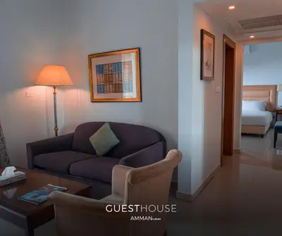 a living room with a couch and a table at Guest House Hotel Amman by FHM in Amman