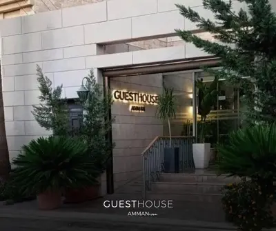 a storefront of a guest house with a sign in the window at Guest House Hotel Amman by FHM in Amman
