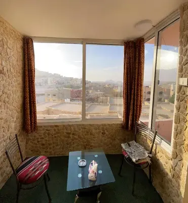 a room with a table and chairs and a large window at Orient Gate in Wadi Musa