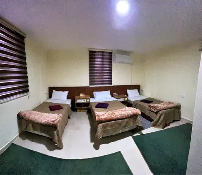 a room with two beds and two ottomans at Orient Gate in Wadi Musa