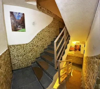 a staircase in a house with a stone wall at Orient Gate in Wadi Musa
