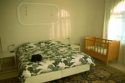 a small bedroom with a bed and a crib at B&B Petra Fig Tree Villa in Wadi Musa