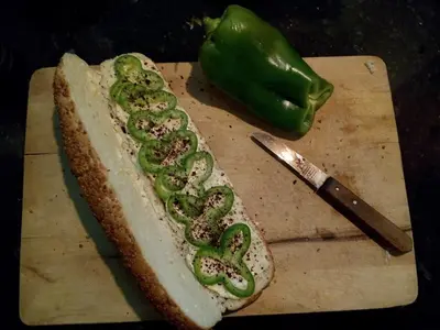 a hot dog with peppers on a cutting board with a knife at B&B Petra Fig Tree Villa in Wadi Musa