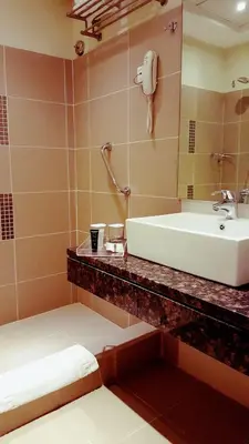 a bathroom with a sink and a mirror at Crystal Hotel in Amman