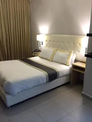 a bedroom with a large bed with white sheets and pillows at Crystal Hotel in Amman