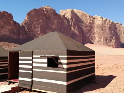 a black and white building in the desert at Black Irish Camp And Tours in Wadi Rum
