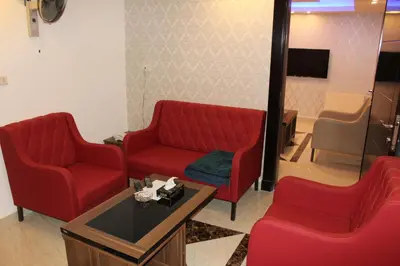 a waiting room with two red chairs and a table at Virginia Hotel in Amman
