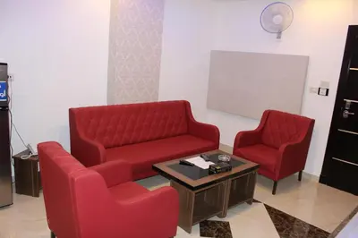 a waiting room with two red chairs and a table at Virginia Hotel in Amman