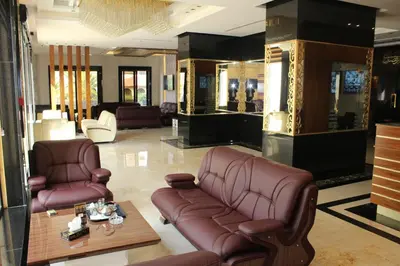 a lobby with a leather couch and chairs and a table at Virginia Hotel in Amman