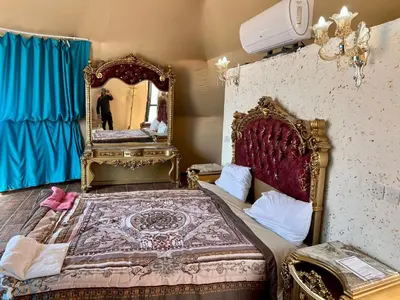 a bedroom with a large bed and a mirror at Jamal Rum desert in Wadi Rum