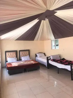 two beds in a room with a tent at Jamal Rum desert in Wadi Rum