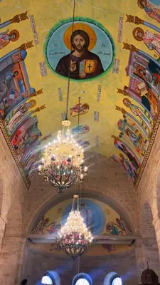 a painting on the ceiling of a church with chandeliers at Pilgrim's Guest House in Madaba