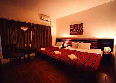 a hotel room with two beds and a window at Amman Pasha Hotel in Amman