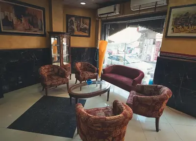 a living room with chairs and a table and a window at Amman Pasha Hotel in Amman