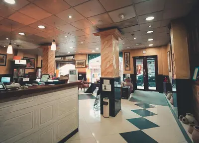 a restaurant with a lobby with a counter and a bar at Amman Pasha Hotel in Amman
