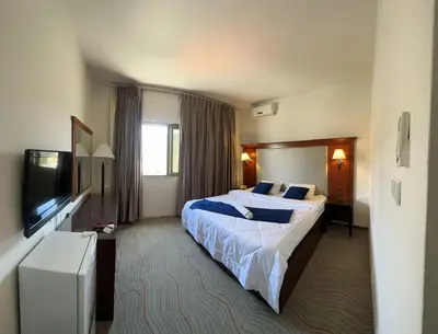 a hotel room with a bed and a flat screen tv at Amman Pasha Hotel in Amman