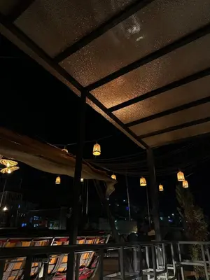a patio with a roof with lights and chairs at Amman Pasha Hotel in Amman