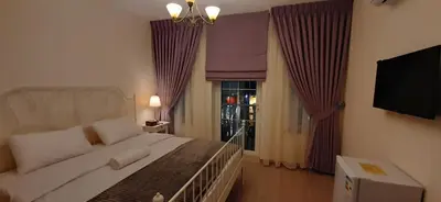 a bedroom with a bed and a television and a window at The Boutique Hotel Amman in Amman