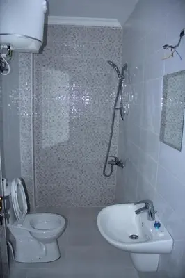 a bathroom with a shower and a toilet and a sink at Weekend Hotel in Aqaba