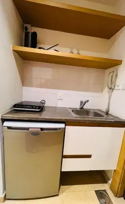 a small kitchen with a sink and a phone at Burda 41 Hotel & Suites in Amman
