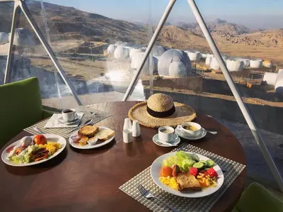 a table with plates of food on it with a view at Petra Bubble Luxotel in Wadi Musa