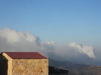 a stone building with a view of a mountain at Ein lahda camp-site in Dana