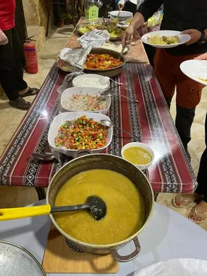 a table with many plates of food on it at Ein lahda camp-site in Dana