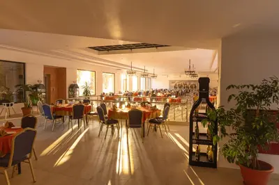 a restaurant with tables and chairs and a bottle of wine at Petra Palace Hotel in Wadi Musa
